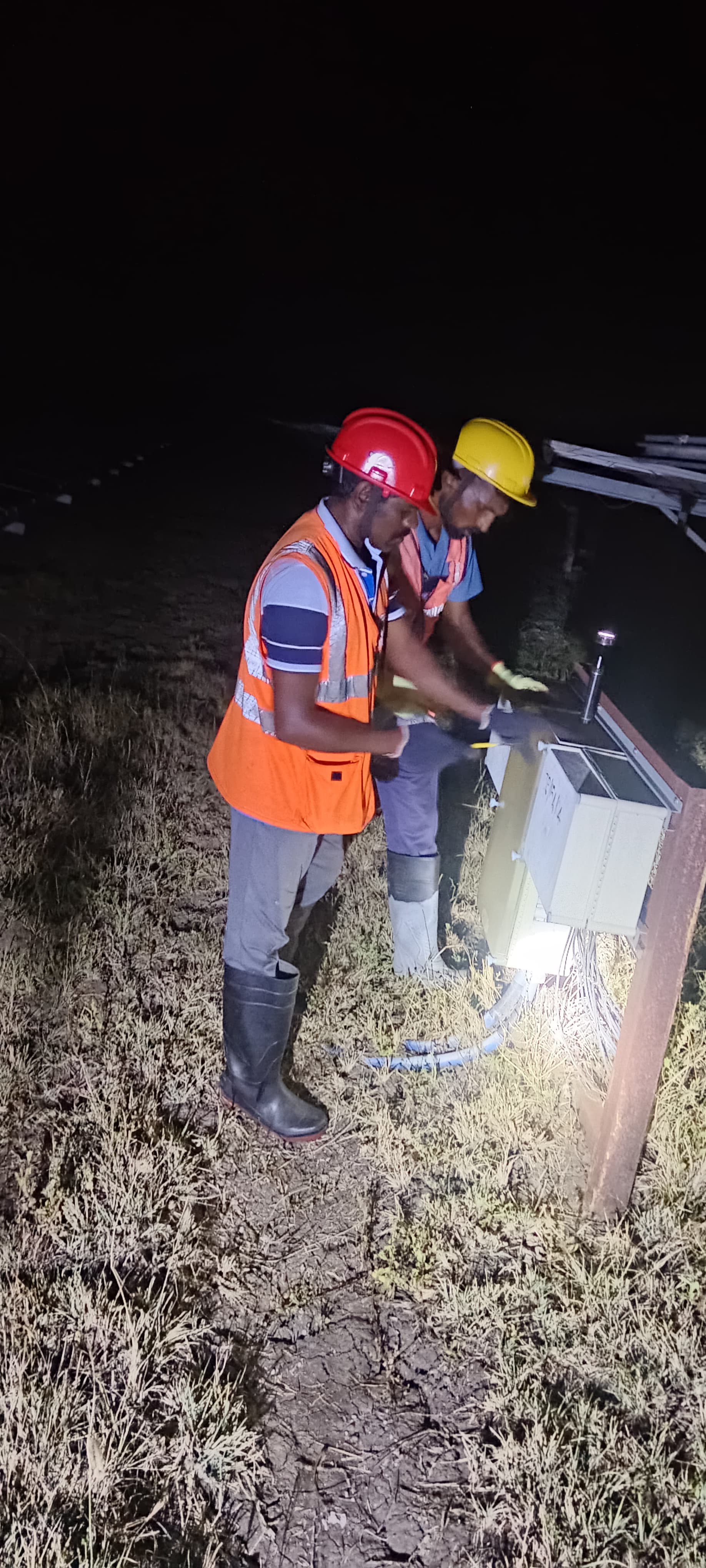 Engineers inspecting and testing solar string combiner box for fault rectification