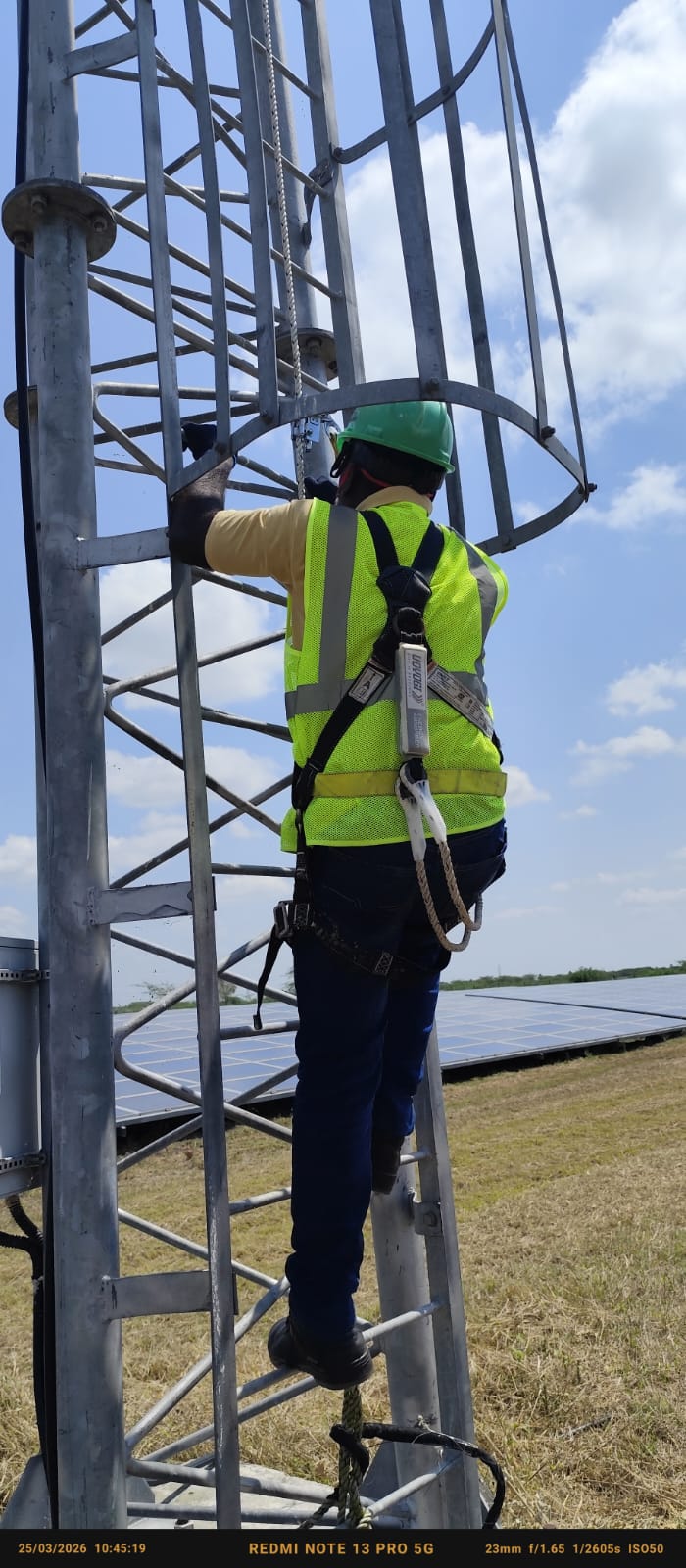 Technician climbing transmission tower for maintenance at solar site